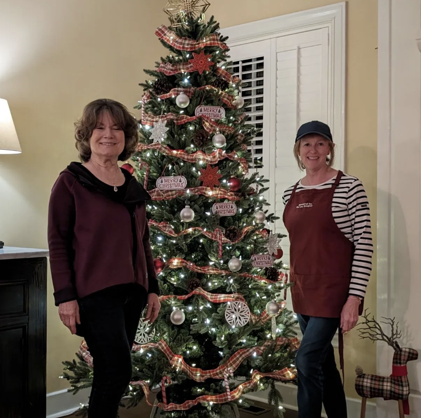 The innkeepers of Ravenscroft Inn beside the Christmas tree